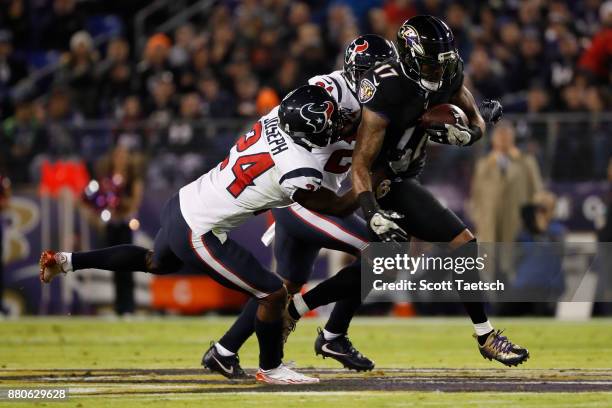 Wide Receiver Mike Wallace of the Baltimore Ravens carries the ball as he is tackled by cornerback Johnathan Joseph of the Houston Texans in the...