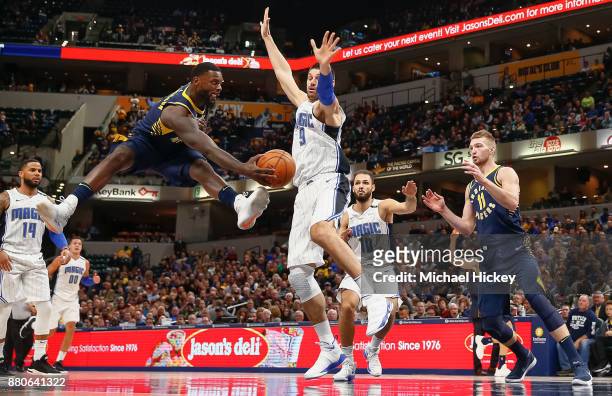 Lance Stephenson of the Indiana Pacers passes the ball off as Nikola Vucevic of the Orlando Magic defends at Bankers Life Fieldhouse on November 27,...