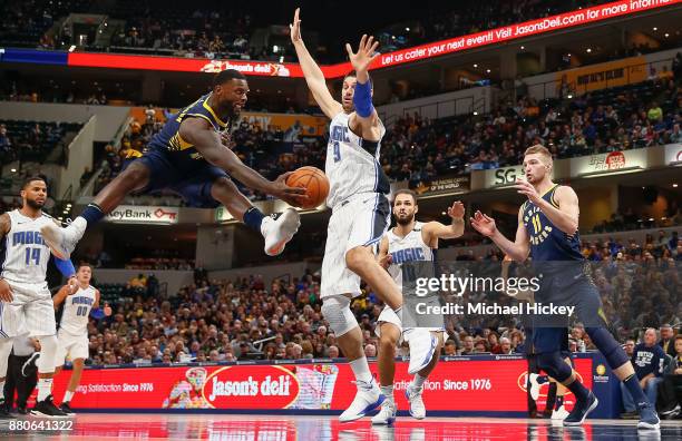 Lance Stephenson of the Indiana Pacers passes the ball off as Nikola Vucevic of the Orlando Magic defends at Bankers Life Fieldhouse on November 27,...