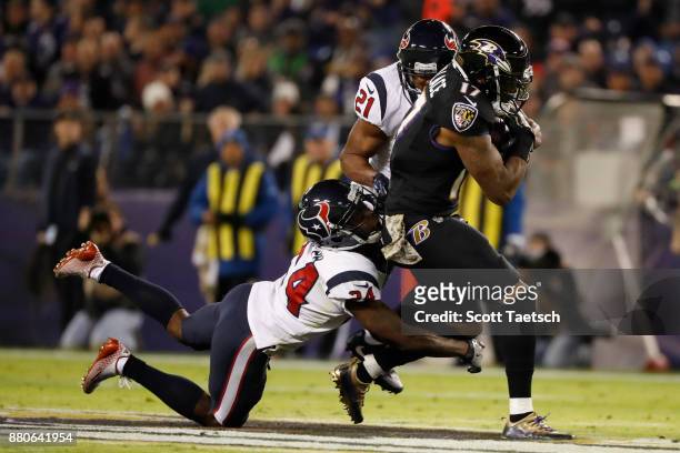 Wide Receiver Mike Wallace of the Baltimore Ravens carries the ball as he is tackled by cornerback Johnathan Joseph of the Houston Texans in the...