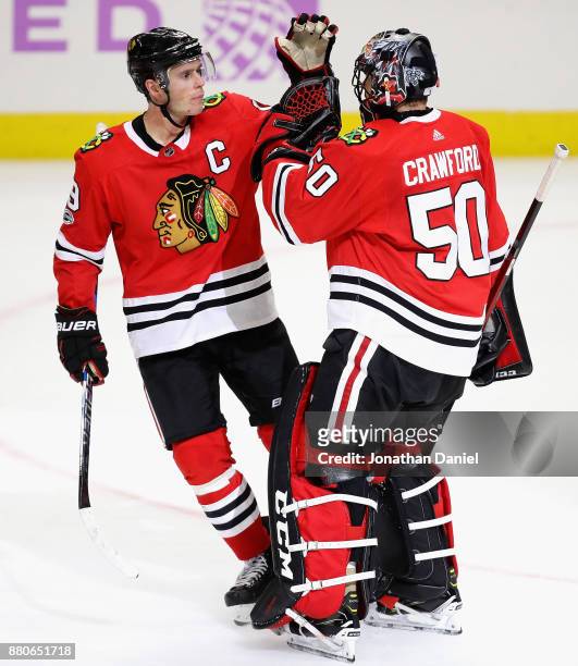 Jonathan Toews of the Chicago Blackhawks congratulates Corey Crawford after a win over the Anaheim Ducks at the United Center on November 27, 2017 in...