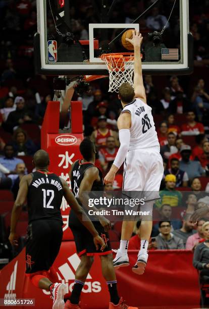 Timofey Mozgov of the Brooklyn Nets dunks the ball in the second half defended by James Harden of the Houston Rockets at Toyota Center on November...