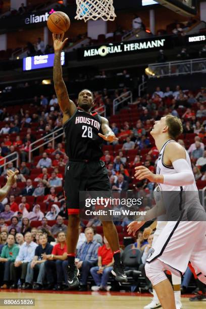 Tarik Black of the Houston Rockets takes a shot defended by Timofey Mozgov of the Brooklyn Nets in the second half at Toyota Center on November 27,...