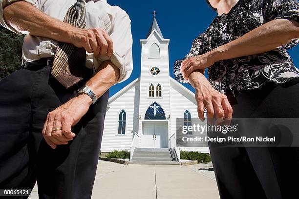 couple rolling up sleeves in front of church - sleeve roll stock pictures, royalty-free photos & images