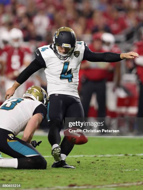 Kicker Josh Lambo of the Jacksonville Jaguars kicks and extra point held by Brad Nortman during the second half of the NFL game against the Arizona...