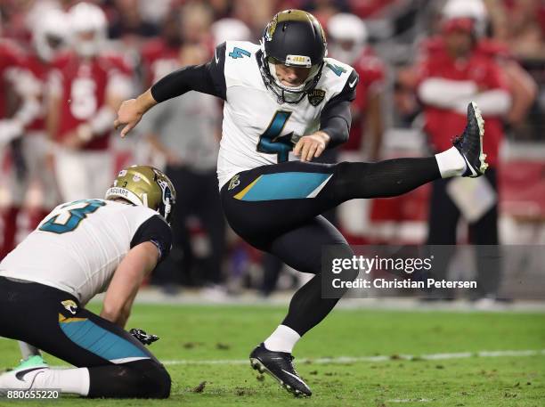 Kicker Josh Lambo of the Jacksonville Jaguars kicks and extra point held by Brad Nortman during the second half of the NFL game against the Arizona...