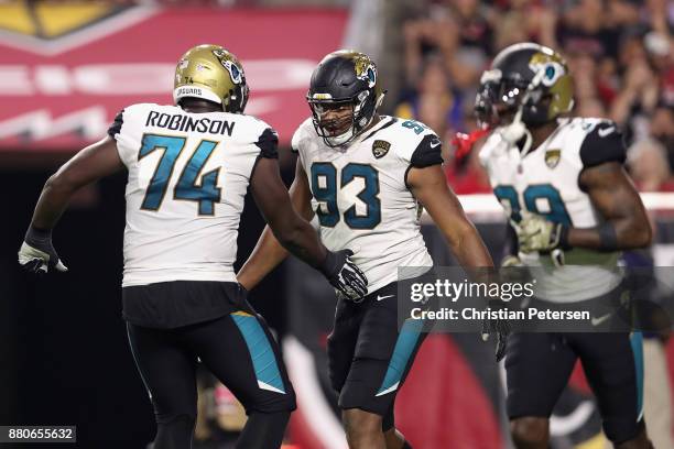 Defensive end Calais Campbell of the Jacksonville Jaguars celebrates with offensive tackle Cam Robinson after scoring a touchdown against the Arizona...