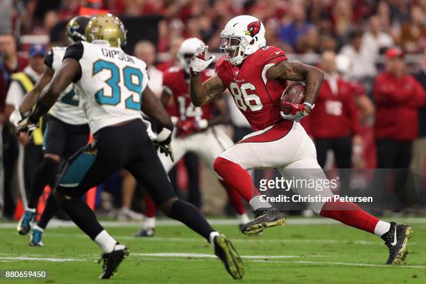 Tight end Ricky Seals-Jones of the Arizona Cardinals runs with the football to score on a 29 yard touchdown ahead of free safety Tashaun Gipson of...