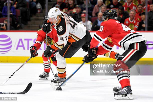 Anaheim Ducks defenseman Hampus Lindholm battles with Chicago Blackhawks right wing John Hayden to take a shot in the third period during a game...