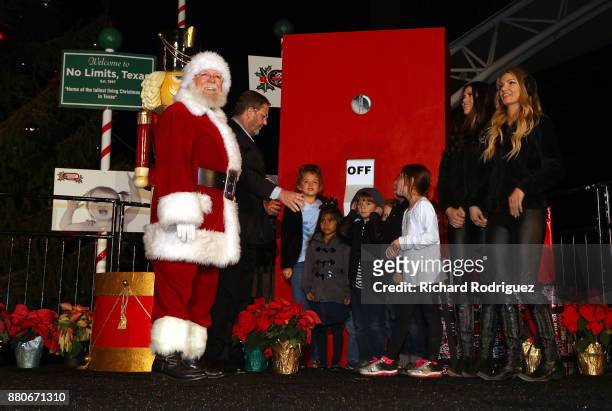 Santa Claus, Texas Motor Speedway President Eddie Gossage and the Great American Sweethearts get ready to light the tree with the help of some child...