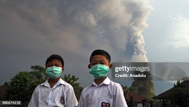 Elementary school students with face masks pose for a photo in a school ground before school in Rendang village of Karangasem, Bali, Indonesia on...