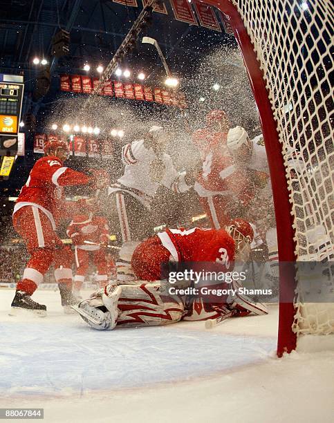 Goalie Chris Osgood of the Detroit Red Wings covers the puck after he made a save against the Chicago Blackhawks during Game Five of the Western...