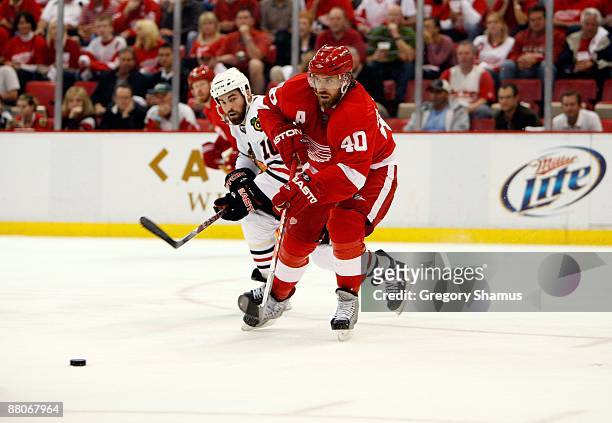 Henrik Zetterberg of the Detroit Red Wings passes the puck against Andrew Ladd of the Chicago Blackhawks during Game Five of the Western Conference...