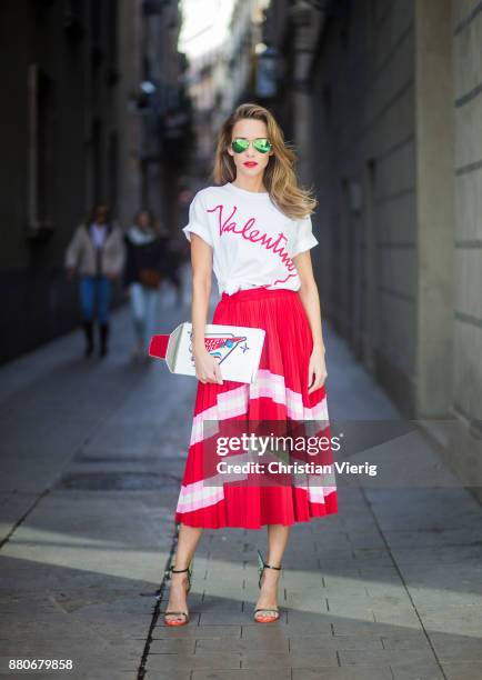 Alexandra Lapp wearing a pleated skirt from Valentino, white t-shirt from Valentino with label print written over the chest with red lipstick, high...