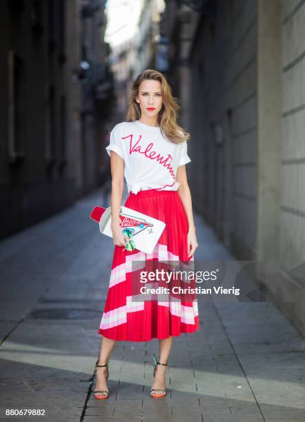 Alexandra Lapp wearing a pleated skirt from Valentino, white t-shirt from Valentino with label print written over the chest with red lipstick, high...
