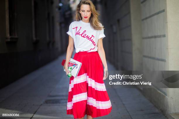 Alexandra Lapp wearing a pleated skirt from Valentino, white t-shirt from Valentino with label print written over the chest with red lipstick, high...