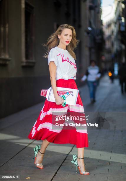 Alexandra Lapp wearing a pleated skirt from Valentino, white t-shirt from Valentino with label print written over the chest with red lipstick, high...