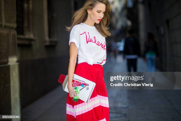 Alexandra Lapp wearing a pleated skirt from Valentino, white t-shirt from Valentino with label print written over the chest with red lipstick, high...