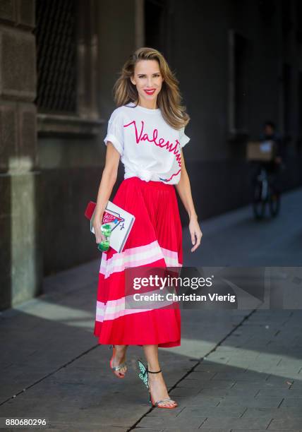 Alexandra Lapp wearing a pleated skirt from Valentino, white t-shirt from Valentino with label print written over the chest with red lipstick, high...
