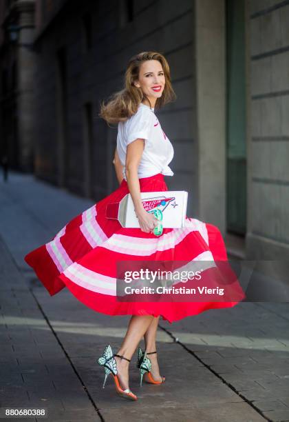 Alexandra Lapp wearing a pleated skirt from Valentino, white t-shirt from Valentino with label print written over the chest with red lipstick, high...