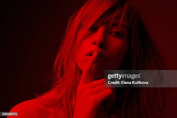 young woman with finger on mouth - shh stock-fotos und bilder