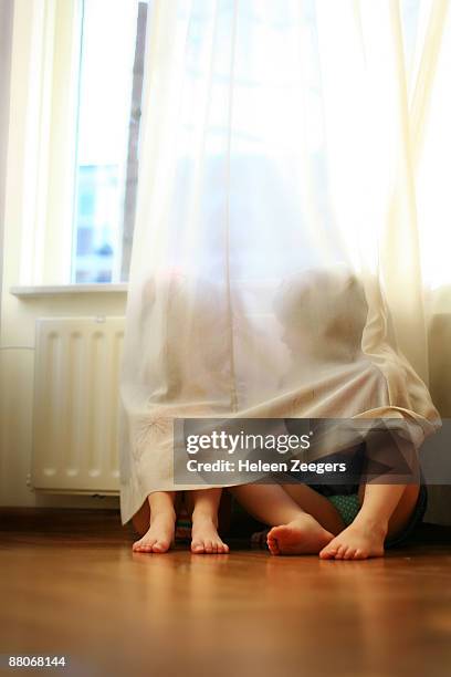 toddlers talking behind a curtain - close to stockfoto's en -beelden