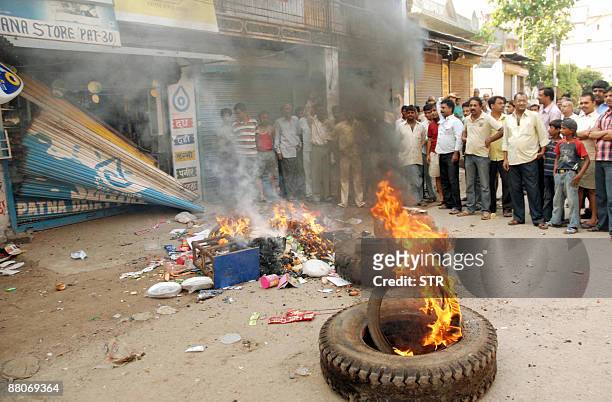 Indian protestors burn tires after damaging a shop belonging to Avinash , one of two suspected kidnappers and killers of Satyam Kumar in Kankarbagh...