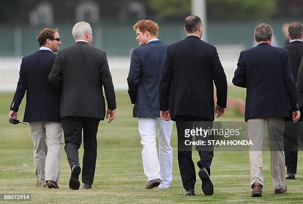 Prince Harry walks with security guards before playing in the second annual Veuve Clicquot Manhattan Polo Classic May 30, 2009 on Governors Island at...