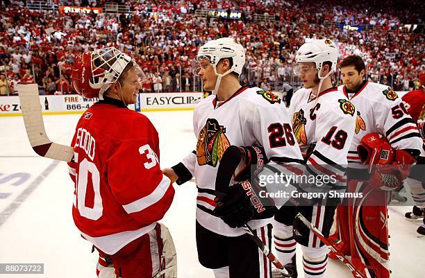 Goalie Chris Osgood of the Detroit Red Wings is congratulated by Samuel Pahlsson of the Chicago Blackhawks after the Red Wings won 2-1 in overtime...