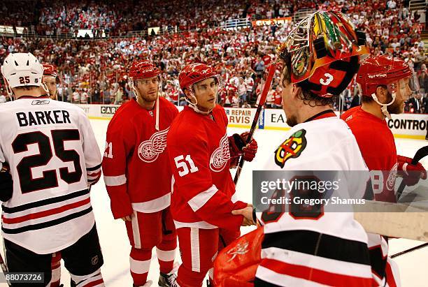 Valtteri Filppula of the Detroit Red Wings is congratulated goalie Cristobal Huet of the Chicago Blackhawks after the Red Wings won 2-1 in overtime...