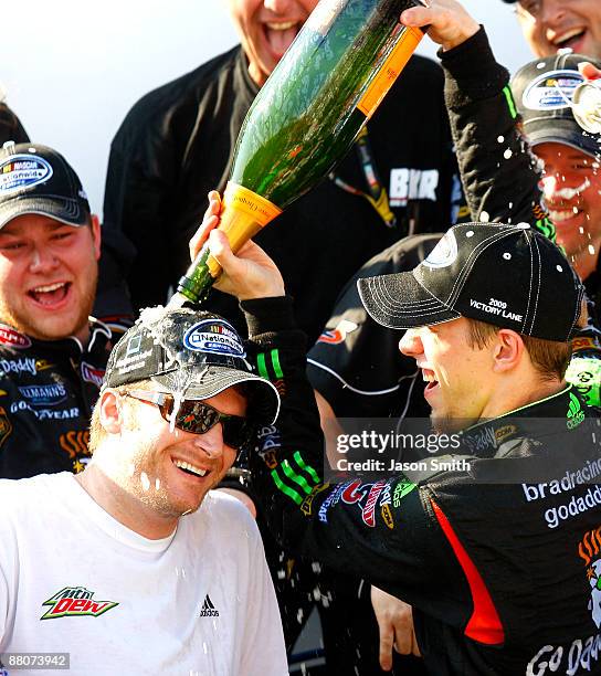 Brad Keselowski , driver of the GoDaddy.com Chevrolet, pours champagne over car owner Dale Earnhardt Jr. In victory lane after winning the NASCAR...