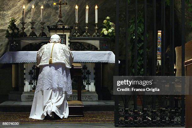 Pope Benedict XVI prays in front of the Lourdes grotto as he leads the ceremony at the Vatican gardens to conclude the Marian month on May 30, 2009...