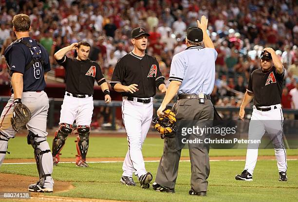 Manager A.J. Hinch of the Arizona Diamondbacks walks onto the field as home plate umpire Jerry Crawford signals for players to return to their...
