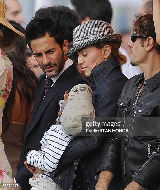 Madonna holds son David as designer Marc Jacobs looks on during the second annual Veuve Clicquot Manhattan Polo Classic May 30, 2009 on Governors...