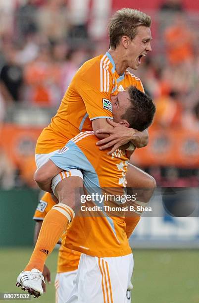 Stuart Holden of the Houston Dynamo celebrates the Dynamo's third goal with Bobby Boswell as the play against Toronto FC at Robertson Stadium on May...