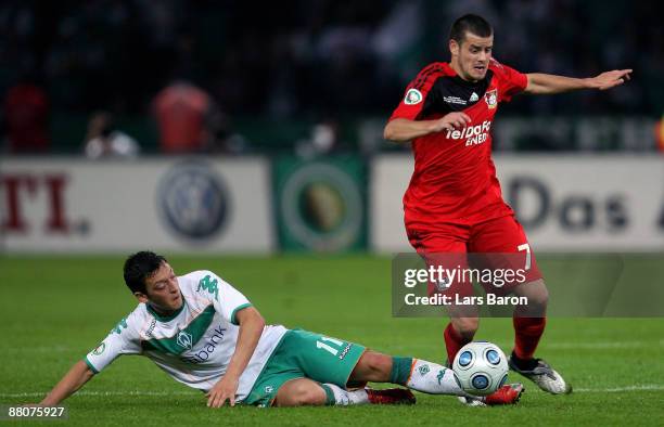 Mesut Oezil of Bremen challenges Tranquillo Barnetta of Leverkusen during the DFB Cup Final match between Bayer 04 Leverkusen and SV Werder Bremen at...