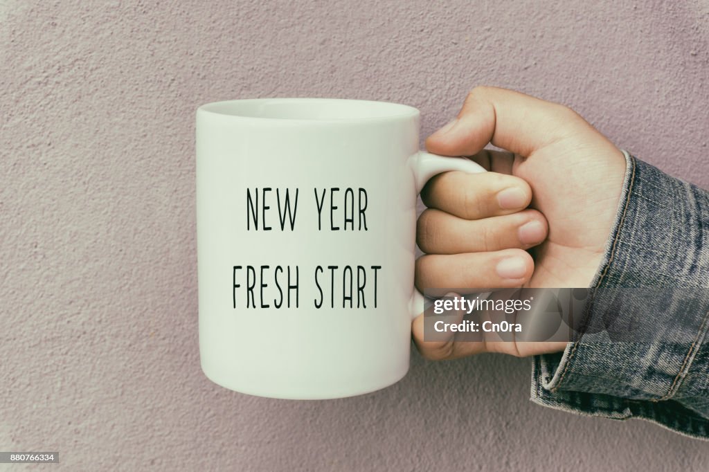 Hands Holding a Coffee Mug With Text New Year Fresh Start