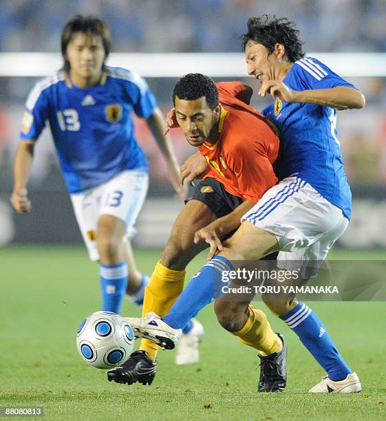 Belgian midfielder Moussa Dembele duels for the ball with Japanese midfielder Hideo Hashimoto and forward Shinzo Koroki during the second half of the...