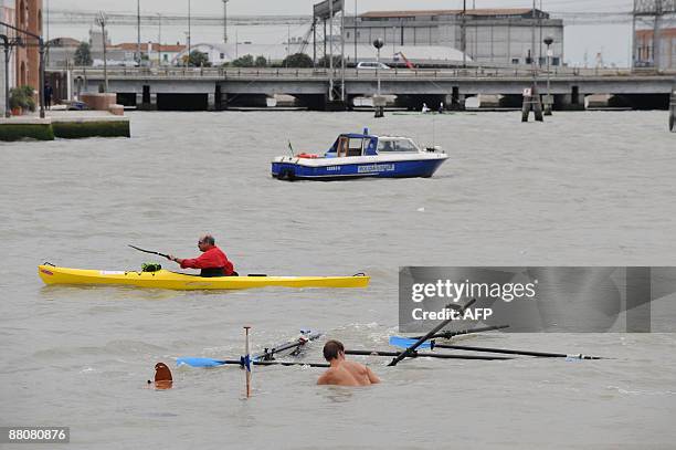 Participant swims in the water after his boat drowned during the 35th Vogalonga rowing boats regatta on Venice's canals on May 31, 2009. Competitors...