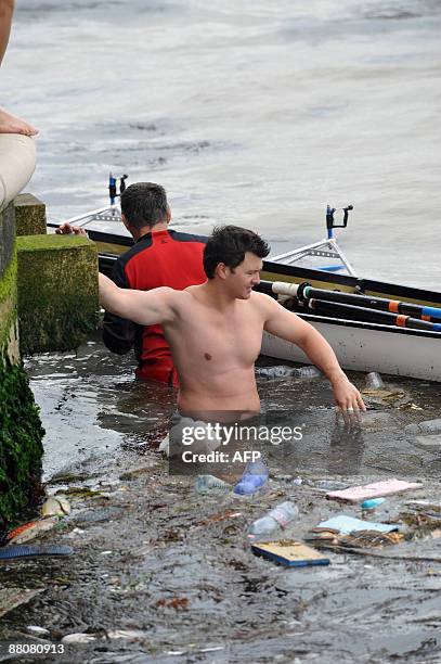 Participant stands in the water after his boat drowned during the 35th Vogalonga rowing boats regatta on Venice's canals on May 31, 2009. Competitors...