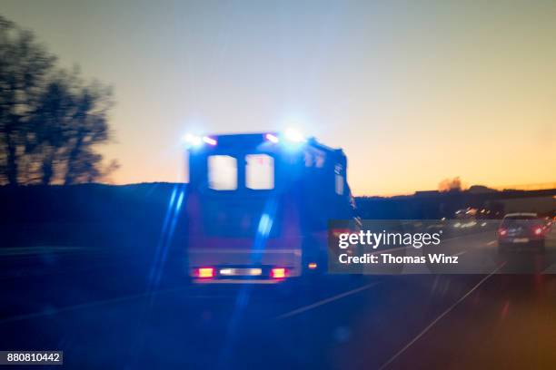 ambulance on freeway at dusk - ambulance stockfoto's en -beelden