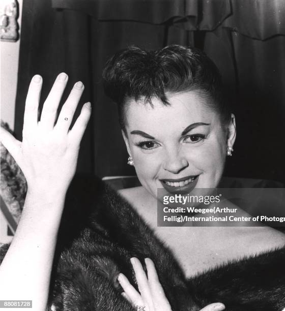 Actress Judy Garland smiles while holding her hands up, ca.1960s.