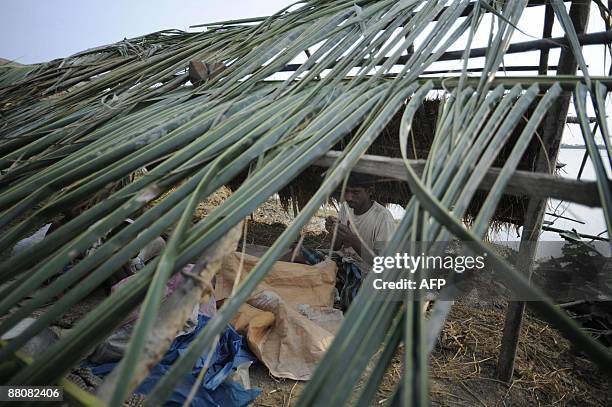 Displaced Bangladeshi villager takes shelter in a makeshift dwelling on the outskirts of Khulna some 400kms from Dhaka on May 31 after his home in...