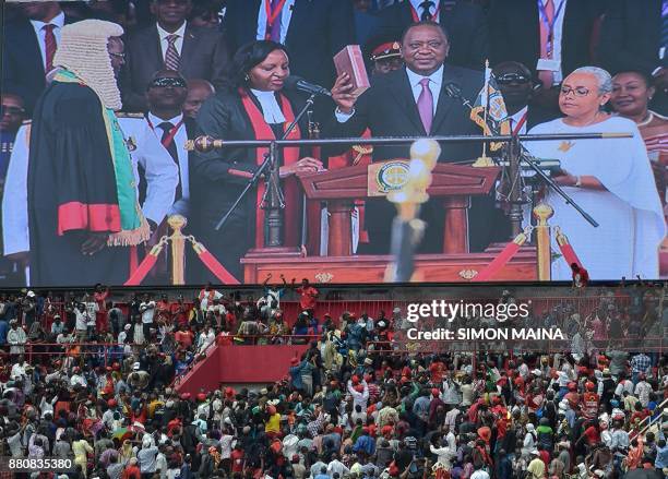 Kenya's President Uhuru Kenyatta appears on a giant screen as he takes oath of office during his inauguration ceremony at Kasarani Stadium on...