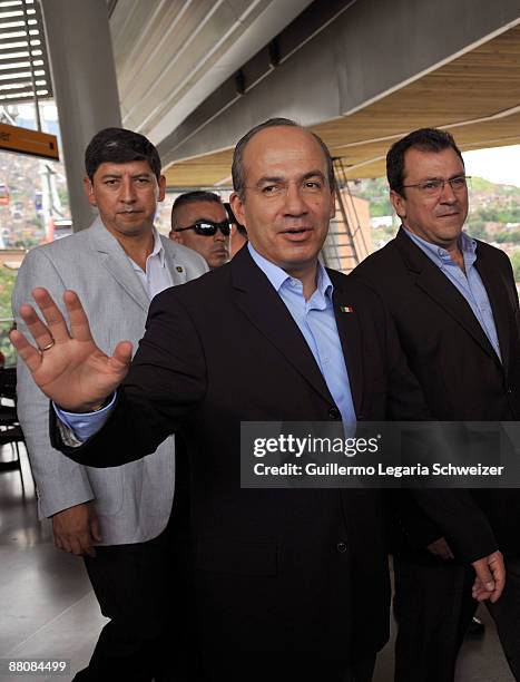 Mexican President Felipe Calderon waves during a visit to the Comuna 13 neighborhood with Medellin's Mayor Alonso Salazar on May 31, 2009 in...