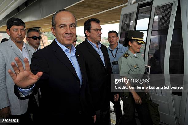 Mexican President Felipe Calderon waves during a visit to the Comuna 13 neighborhood with Medellin's Mayor Alonso Salazar on May 31, 2009 in...