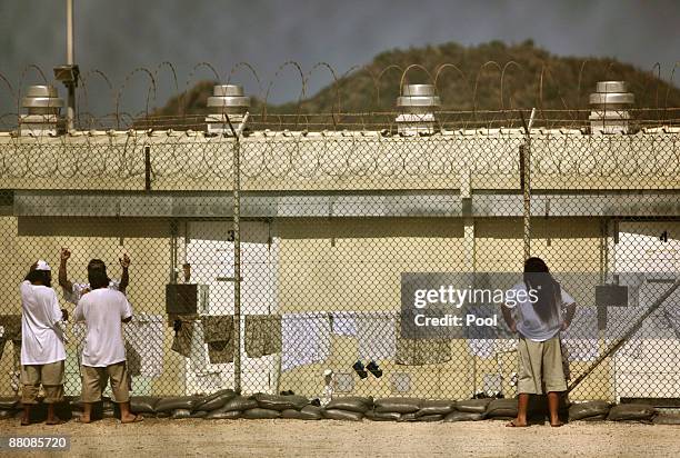 Detainees talk together inside the open-air yard at Camp 4 detention facility on May 31, 2009 at U.S. Naval Base Guantanamo Bay, Cuba. Former child...