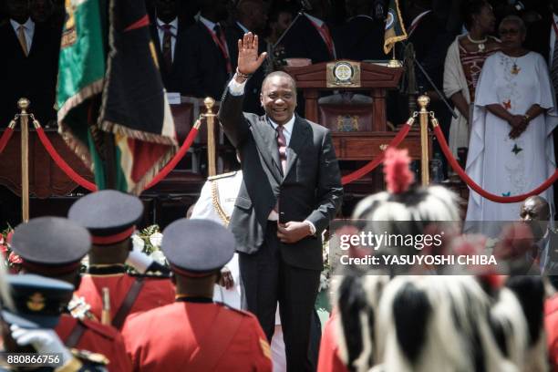 Kenya's President Uhuru Kenyatta waves to guards of honour upon his arrival to take oath of office during his inauguration ceremony at Kasarani...