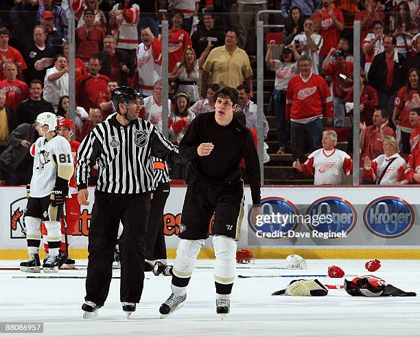 Linesman Steve Miller escorts Evgeni Malkin of the Pittsburgh Penguins off the ice after a fight with Henrik Zetterberg of the Detroit Red Wings with...