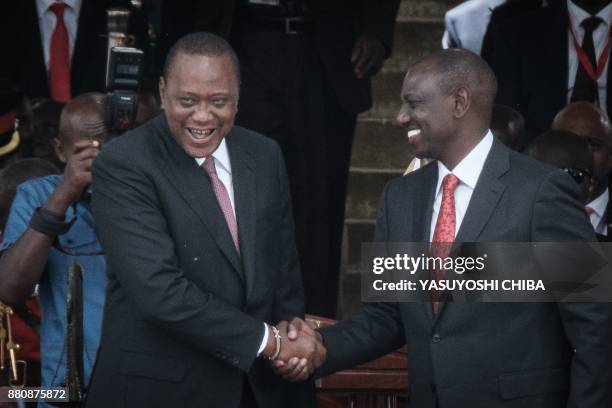 Kenya's President Uhuru Kenyatta and Vice-President William Ruto shake hands after taking oath of office during the inauguration ceremony at Kasarani...